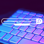 Computer keyboard and search bar with "SEARCH ENGINE OPTIMIZATION" typed in for keyword research and analysis
